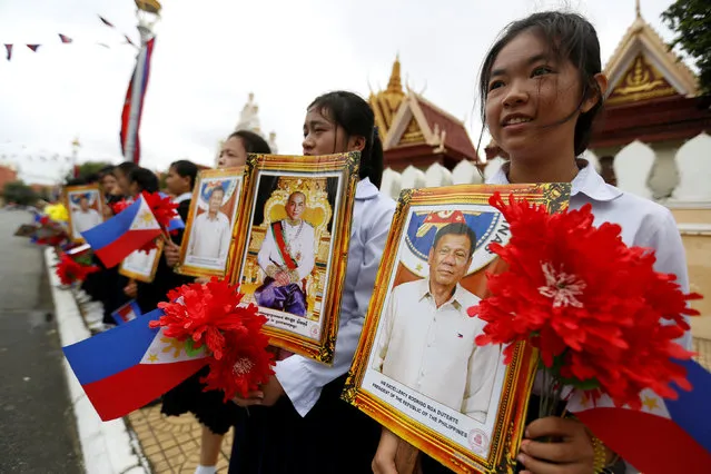 Student hold portraits of Philippine President Rodrigo Duterte and Cambodian King Norodom Sihamoni during a meeting at the Royal Palace in central Phnom Penh, Cambodia December 14, 2016. (Photo by Samrang Pring/Reuters)