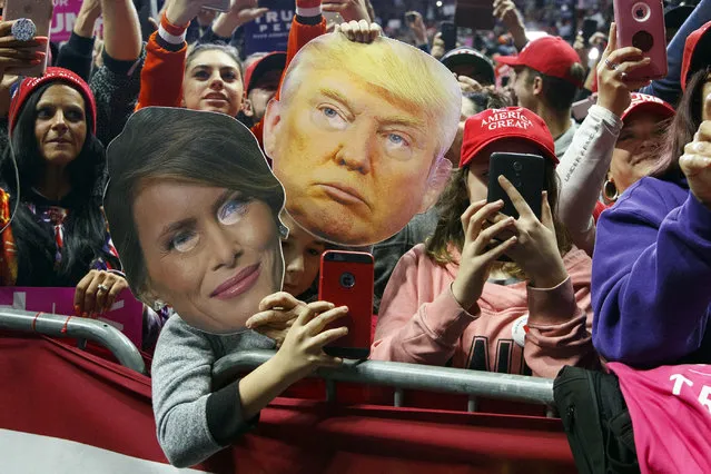 James Crockett, 10, holds a mask of President Donald Trump as another supporter holds a mask of first lady Melania Trump as President Donald Trump speaks at a rally at Allen County War Memorial Coliseum, Monday, November 5, 2018, in Fort Wayne, Ind.. (Photo by Carolyn Kaster/AP Photo)