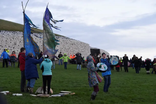 Revellers celebrate during winter solstice at the 5000 year old stone age tomb of Newgrange in the Boyne Valley at sunrise in Newgrange, Ireland, December 21, 2016. (Photo by Clodagh Kilcoyne/Reuters)