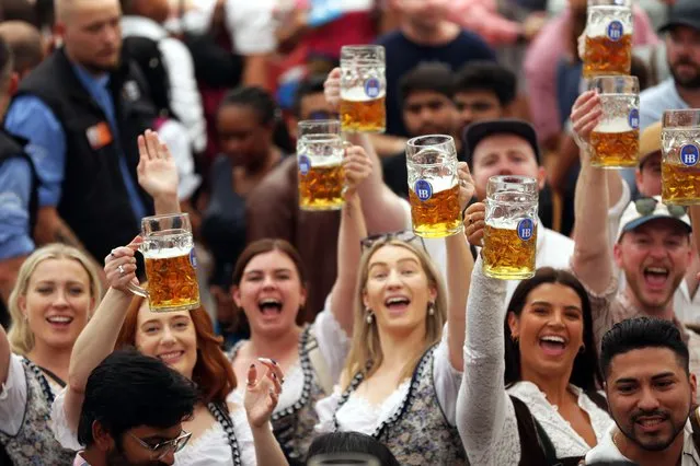 Revelers cheer with beer mugs inside the Hofbraeuhaus trent on the opening day of the 2023 Munich Oktoberfest on September 16, 2023 in Munich, Germany. This year's Oktoberfest will run through October 3 and is expected to draw millions of visitors. (Photo by Johannes Simon/Getty Images)