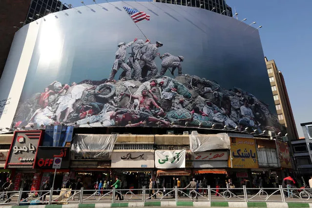A picture taken on January 18, 2016 shows an anti-US banner inspired by American photographer Joe Rosenthal's iconic World War II photograph “Raising the Flag on Iwo Jima” displayed on a building in the capital Tehran. (Photo by Atta Kenare/AFP Photo)