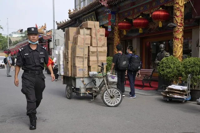 A security guard passes by deliveries along the Wangfujing retail street in Beijing Wednesday, July 14, 2021. (Photo by Ng Han Guan/AP Photo)
