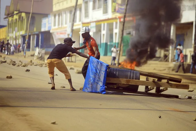 Protesters set up a barricade in the Eastern Congolese town of Beni Thursday December 27, 2018. Police in eastern Congo have fired live ammunition and tear gas to disperse dozens of people protesting a presidential election delay that means more than 1 million votes will not count. The protesters in Beni say the delay announced by Congo's electoral commission makes no sense. The delay of Sunday's election until March for Beni and Butembo city is blamed on a deadly Ebola outbreak. The rest of the country will vote on time. (Photo by Al-hadji Kudra Maliro/AP Photo)