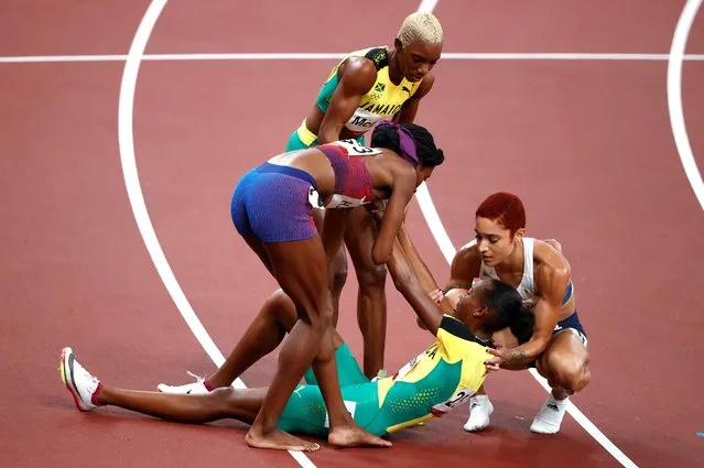 Allyson Felix of the United States, Jodie Williams of Britain and Candice McLeod of Jamaica help Stephenie McPherson of Jamaica during the women's 400m final during the Tokyo 2020 Olympic Games at the Olympic Stadium in Tokyo on August 6, 2021. (Photo by Phil Noble/Reuters)