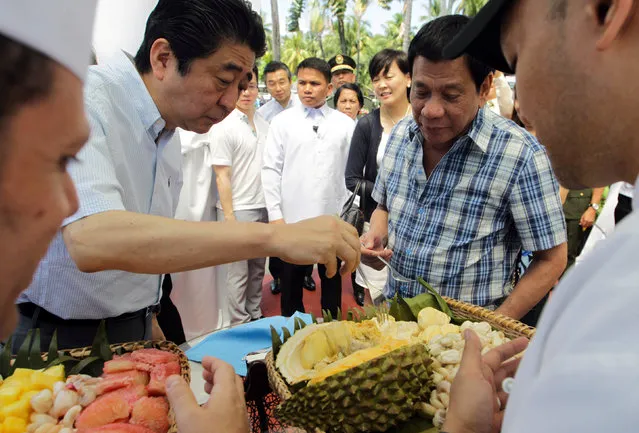 President Rodrigo Duterte and Japan's Prime Minister Shinzo Abe (L) try durian fruit after attending various events at the Waterfront Hotel in Davao City, southern Philippines January 13, 2017. (Photo by Reuters/Malacanang Photo)