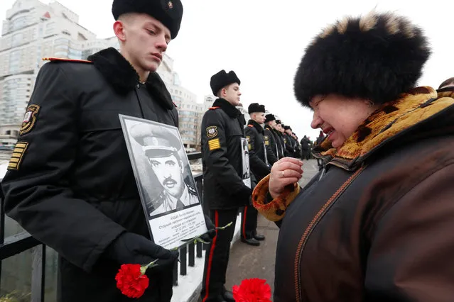 Svetlana Khodak, 66, looks at a portrait of her husband Victor, killed in Afghanistan, during a wreath laying ceremony near a monument commemorating the Soviet victims of the war in Afghanistan, in Minsk, Belarus February 15, 2019. (Photo by Vasily Fedosenko/Reuters)
