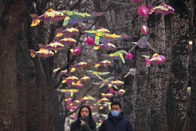 People walk through colorful fish on display along a pedestrian pathway in Beijing, Tuesday, January 2, 2024. (Photo by Andy Wong/AP Photo)