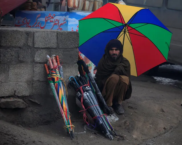A man waits for customers while selling umbrellas in the rain in Rawalpindi, Pakistan January 18, 2017. (Photo by Faisal Mahmood/Reuters)