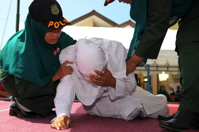 An Indonesian woman known as Linda (C) is helped by two Sharia officials after being caned for spending time in close proximity with a man who is not her husband, which is against Sharia law, in Banda Aceh on February 2, 2017. Aceh is the only province in the world's most populous Muslim-majority country that imposes sharia law. People can face floggings for a range of offences – from gambling, to drinking alcohol, to gay s*x. (Photo by Chaideer Mahyuddin/AFP Photo)