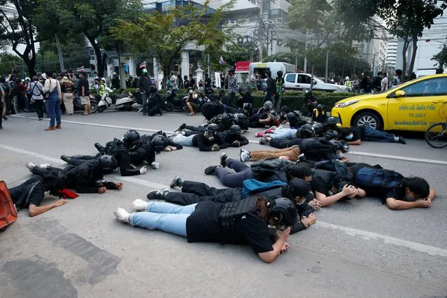 Demonstrators take cover from rubber bullets during a clash with the police while protesting against the amendment of the lese majeste law, in Bangkok, Thailand on November 14, 2021. (Photo by Soe Zeya Tun/Reuters)