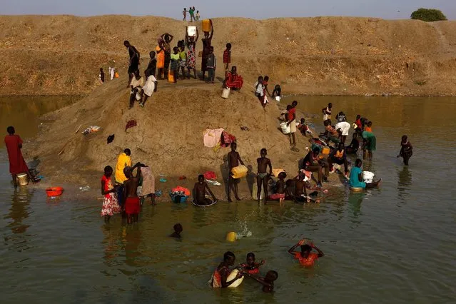 Internally displaced people wash and collect water in a reservoir in the United Nations Mission in South Sudan (UNMISS) Protection of Civilian site (CoP), near Bentiu, northern South Sudan, February 6, 2017. (Photo by Siegfried Modola/Reuters)