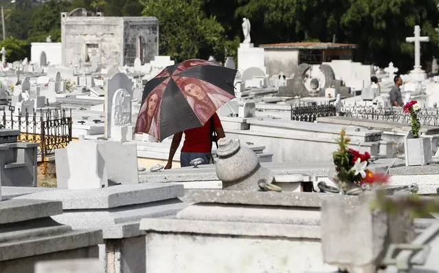 A woman walks among tombstones in the Colon Cemetery during Mother's Day in Havana, Cuba, Sunday, May 10, 2015. (Photo by Desmond Boylan/AP Photo)