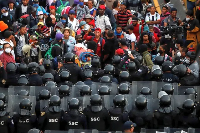 Central American migrants face police from the Secretariat of Citizen Security (SSC), who impeded their advance, in Mexico City, Mexico, 12 December 2021. About 500 Central Americans from the migrant caravan that left Chiapas more than a month and a half ago arrived in Mexico City where they found a police blockade against which they faced with sticks and stones. (Photo by Madla Hartz/EPA/EFE)