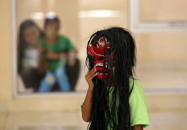 A counsellor and a recently rescued child (L) watch another child play with a mask at a state-run rehabilitation centre in Jakarta, Indonesia April 4, 2016. Authorities in the sprawling Indonesian capital are cracking down on the exploitation of children after a raft of cases, from child labour to violence and sexual assault, was uncovered in recent weeks. (Photo by Darren Whiteside/Reuters)