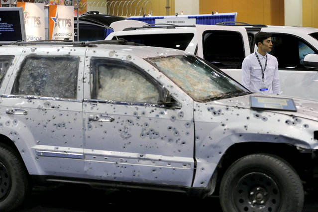 Patricio Canavati, of TPS Armoring stands between two vehicles that his company armored, one with over 1,800 bullet holes, and a newly armored SUV, at the 8th annual Border Security Expo, Tuesday, March 18, 2014 in Phoenix. The bullet riddled SUV saved the life of secretary of Public Security of the state of Michoacan, Mexico, Minerva Bautista Gomez in 2010. The two day event will feature panel discussions, sharing intelligence, and exhibitors displaying high-tech wares aimed at securing lucrative government contracts and private sales. (Photo by Matt York/AP Photo)