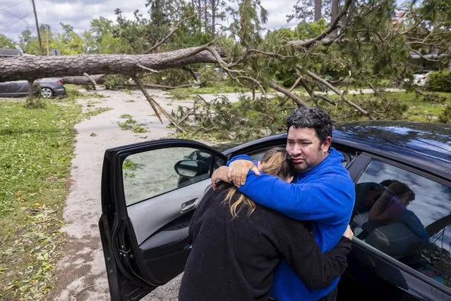 Max Gonzales hugs his girlfriend, April Martin, while leaning against their car taking in the surrounding tornado damage where his parents, Michael and Lilian Bray, live in Slidell, La., on Thursday, April 11, 2024. The neighborhood was picking up the pieces the day after a tornado swept through the area. (Photo by Chris Granger/The Times-Picayune/The New Orleans Advocate via AP Photo)