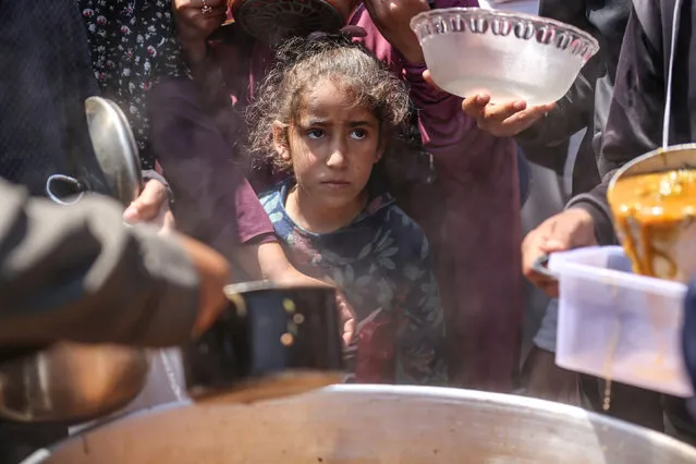 Displaced Palestinians are receiving cooked food rations at a donation point in Deir al-Balah in the central Gaza Strip, on April 16, 2024, amid ongoing battles between Israel and the Palestinian militant group Hamas. (Photo by Majdi Fathi/NurPhoto/Rex Features/Shutterstock)