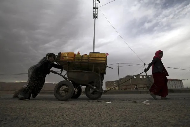 Internally displaced children transport water with a cart in the district of Khamir of Yemen's northwestern province of Amran May 9, 2015. (Photo by Mohamed al-Sayaghi/Reuters)