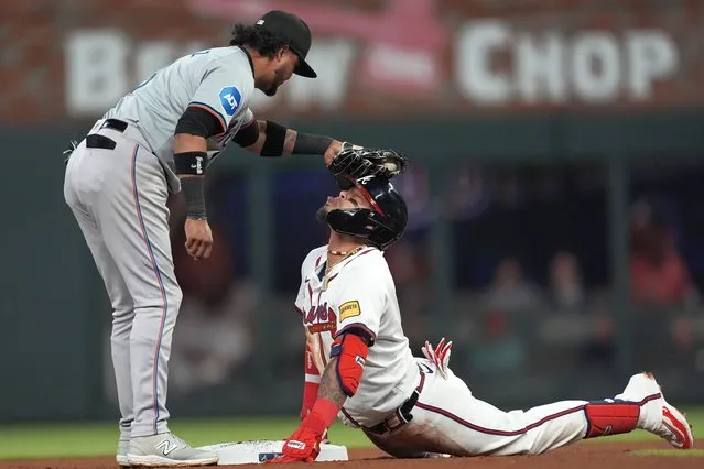 Atlanta Braves' Orlando Arcia is playfully tagged on the head by Miami Marlins second base Luis Arraez (3) after sliding into second base with a double in the seventh inning of a baseball game Monday, April 22, 2024, in Atlanta. (Photo by John Bazemore/AP Photo)