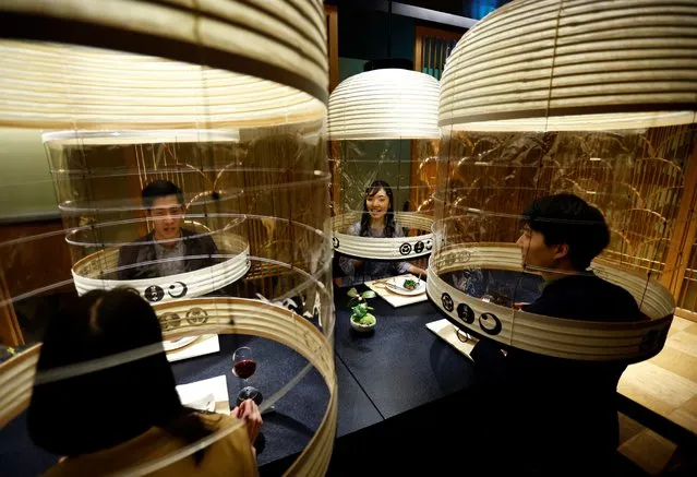 Hotel staff demonstrates “Lantern Dining Experience”, which enables diners to enjoy meals while protecting themselves against the spread of the coronavirus disease (COVID-19) at Hoshinoya Tokyo in Tokyo, Japan, February 2, 2022. The lantern-shaped transparent partitions are created by Japan’s traditional craftsman and guests staying at the hotel who pay 30,000 yen (about 260 USD) as venue charge can invite others to dine with them under the partitions. (Photo by Kim Kyung-Hoon/Reuters)