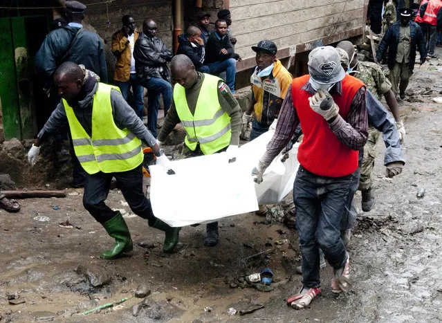 Volunteers carry a body retrieved from the rubble at the site of a building collapse in Nairobi, Kenya, Saturday, April 30, 2016. (Photo by Sayyid Abdul Azim/AP Photo)