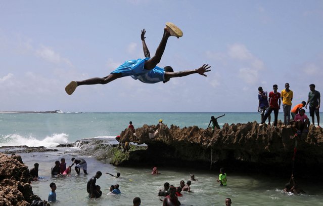 A man jumps into the Indian Ocean waters to join other revellers in Hamarweyne district of Mogadishu, Somalia on June 7, 2024. (Photo by Feisal Omar/Reuters)