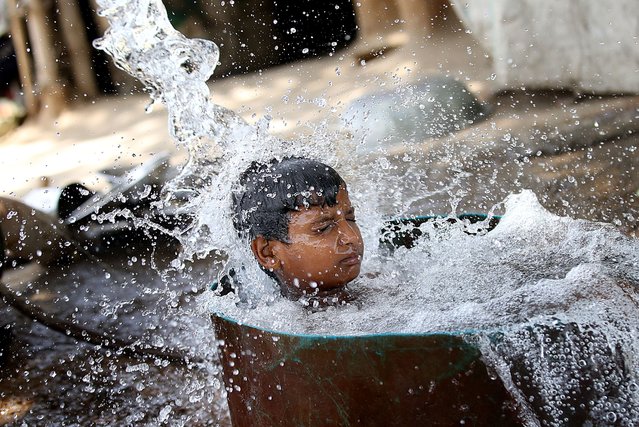 A boy bathes to cool himself in a tubewell on a hot day at the fields in New Delhi, India, 31 May 2024. The India Meteorological Department (IMD) has issued a heat red alert for Delhi, Rajasthan, Haryana, Punjab, and Madhya Pradesh. The IMD Director General M Mohapatra said they are checking the temperature sensor in Delhi's Mungeshpur automatic weather station to see if it is working properly, as there were temperatures of over 50 degrees Celsius recorded on 29 May, and the weather department has reported that the maximum temperature is anticipated to reach around 44 degrees Celsius, in the Indian capital. (Photo by Harish Tyagi/EPA/EFE)