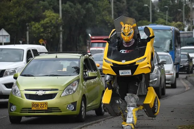 Luis Cruz looks at the camera while working with his transformers suit at a traffic light in Bogotá, Colombia on January 26, 2021 The story of Luis Cruz, a man who decided to create the robots of the movie Transformers, which marked his childhood and because of his family's situation he was never able to obtain a toy of his characters. More than ten years ago he used these costumes created by him in a specific traffic light, in which he can make 20 transformations (from car to robot) in one hour, together with his family they have created different robots and Luis has managed to be recognized in different spaces and exhibitions for his work. (Photo by Lina Gasca M/Anadolu Agency via Getty Images)