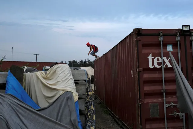 A man jumps from a container at a makeshift camp for migrants and refugees at the Greek-Macedonian border near the village of Idomeni, Greece, May 10, 2016. (Photo by Marko Djurica/Reuters)