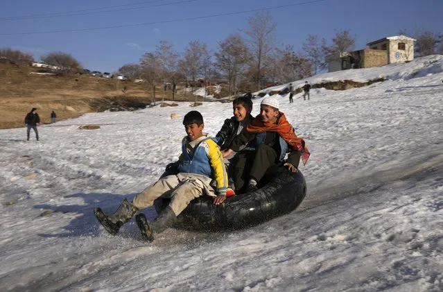 Afghan boys play in the snowt Qargha Lake where many citizens enjoy their weekends, in Kabul, Afghanistan, Thursday, February 10, 2022. (Photo by Hussein Malla/AP Photo)