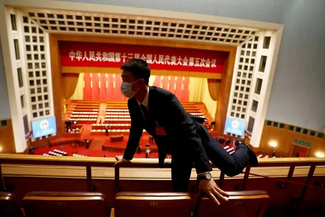 A security personnel keeps watch before the second plenary session of the National People's Congress (NPC) at the Great Hall of the People in Beijing, China on March 8, 2022. (Photo by Carlos Garcia Rawlins/Reuters)