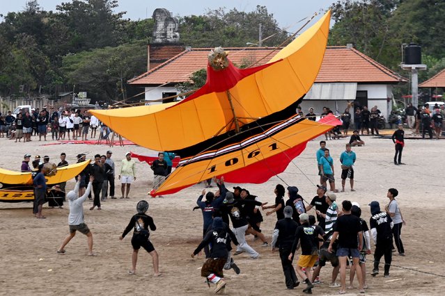 Participants launch a giant kite during the Bali Kite Festival at Mertasari beach in Sanur, Indonesia's Bali island on June 23, 2024. (Photo by Sonny Tumbelaka/AFP Photo)