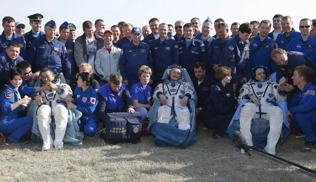 From left, Japanese astronaut Koichi Wakata, Russian cosmonaut Mikhail Tyurin and U.S. astronaut Rick Mastracchio sit in chairs shortly after the landing of the Russian Soyuz TMA-11 space capsule about 150 kilometers (93 miles) southeast of the Kazakh town of Dzhezkazgan, Kazakhstan, Wednesday, May 14, 2014. The Soyuz space capsule with Wakata, Tyurin and Mastracchio returning from a half-year mission to the International Space Station landed safely Wednesday on the steppes of Kazakhstan. (Photo by Dmitry Lovetsky/AP Photo)