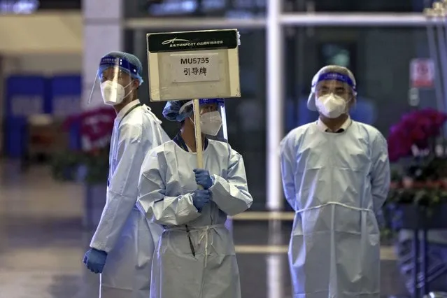 A worker from the China Eastern holds a signboard waiting to lead relatives of the victims aboard China Eastern's flight MU5735 to a cordoned off area, in Guangzhou Baiyun International Airport in Guangzhou, capital of south China's Guangdong Province, Monday, March 21, 2022. A China Eastern Boeing 737-800 with 132 people on board crashed in the southern province of Guangxi on Monday, officials said. (Photo by Chinatopix via AP Photo)