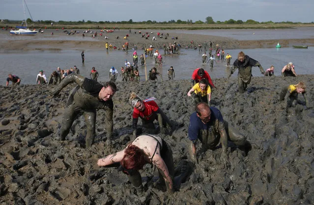Participants arrive at the finish line during the annual Maldon Mud Race in Maldon, east England on May 7, 2017. Originating in 1973, the race involves competitors racing around a course through the River Blackwater in Essex at low tide. (Photo by Daniel Leal-Olivas/AFP Photo)
