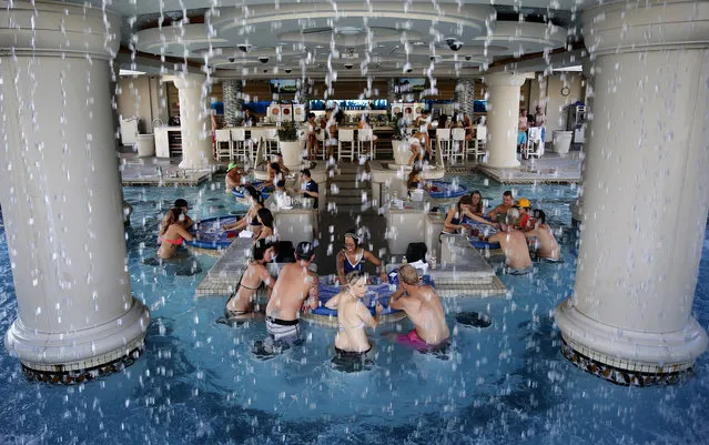 In this Tuesday, July 7, 2015 photo, people play blackjack in a pool at Caesars Palace in Las Vegas. (Photo by John Locher/AP Photo)