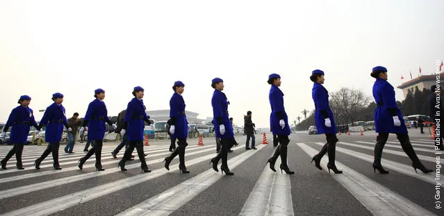 Hostesses for the National People's Congress (NPC)  walk across in front of the Great Hall of the People on March 5, 2012 in Beijing, China
