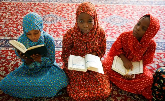 Muslim girls read the Koran before the start of the Friday prayers during the holy fasting month of Ramadan inside Jamia mosque in Nairobi, Kenya on April 8, 2022. (Photo by Monicah Mwangi/Reuters)