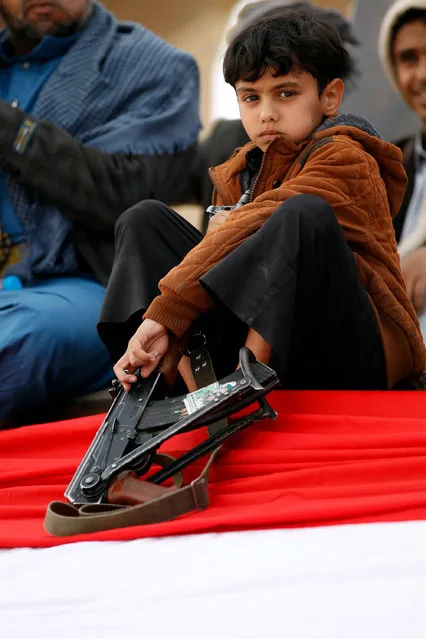 A Yemeni child holds a weapon during an anti- US protest staged by supporters of the Huthi rebels in Sanaa on May 20, 2017. US President Donald Trump began an official visit to Saudi Arabia, which for more than two years has led a coalition conducting air strikes and other operations against rebels in Yemen. (Photo by Mohammed Huwais/AFP Photo)