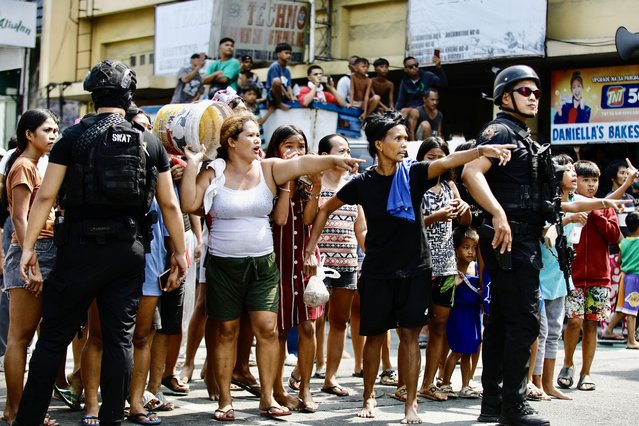 Filipino informal settlers gesture next to anti-riot police during a demolition raid at a shanty town in Pasay City, Metro Manila, Philippines, 01 August 2024. (Photo by Francis R. Malasig/EPA)