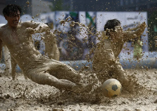 Players battle for the ball during their match at the swamp soccer China tournament in Beijing, June 26, 2014. The 32 teams from across the country participated in the soccer event to celebrate the 2014 World Cup in Brazil. (Photo by Kim Kyung-Hoon/Reuters)