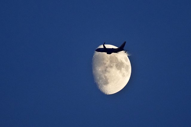 A Southwest Airlines plane is seen from inside Guaranteed Rate Field during the third inning of a baseball game between the Chicago White Sox and the Oakland Athletics, passes a waxing gibbous moon as it heads East, after taking off from Midway International Airport on Friday, September 13, 2024, in Chicago. (Photo by Charles Rex Arbogast/AP Photo)