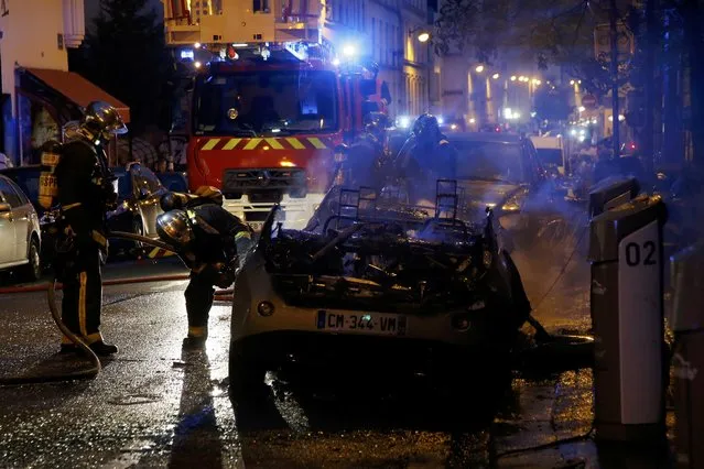 French firemen inspect one of two Autolib' electric cars that were set on fire on a street at the end of a day of nationwide protests against plans to reform French labour laws in Paris, France, June 14, 2016. (Photo by Jacky Naegelen/Reuters)