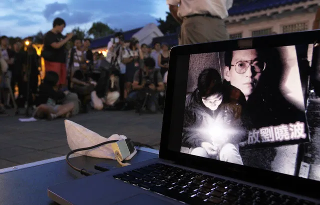 A computer screen shows an image of Nobel Peace Prize laureate Liu Xiaobo during a ceremony to mourn late Liu, China's most famous political prisoner, at Democracy Square in Taipei, Taiwan, Friday, July 14, 2017. Liu died Thursday of liver cancer at 61. (Photo by Chiang Ying-ying/AP Photo)