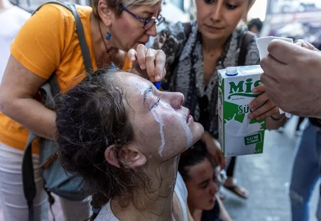 People pour milk to the eyes of a protester affected by tear gas as protesters clash with police as they commemorate 9th anniversary of Gezi park protests, in which hundreds of thousands marched in Istanbul and elsewhere in Turkey in 2013 as demonstrations against plans to build a replica Ottoman barracks in the city's Gezi Park and grew into nationwide protests against President Tayyip Erdogan's government, in Istanbul, Turkey on May 31, 2022. (Photo by Umit Bektas/Reuters)