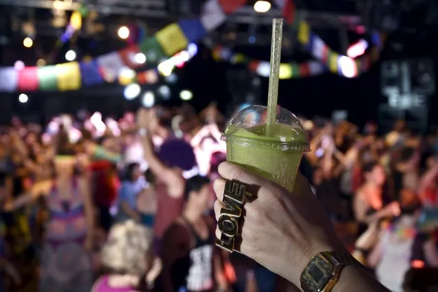 A reveller holds her cup of fruit smoothie at “Morning Gloryville” at the Ministry of Sound in south London August 11, 2015. (Photo by Toby Melville/Reuters)