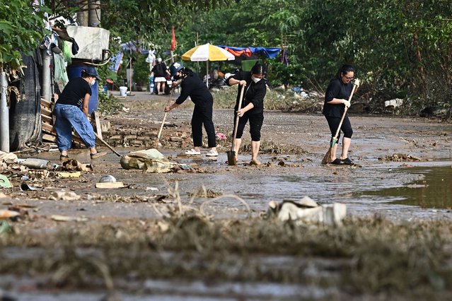 Residents clean up after flood waters receded in Hanoi on September 13, 2024. (Photo by Nhac Nguyen/AFP Photo)