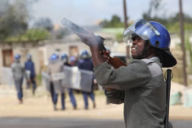 Armed Zimbabwean police battle rioters in Harare, Monday, July, 4, 2016. (Photo by Tsvangirayi Mukwazhi/AP Photo)