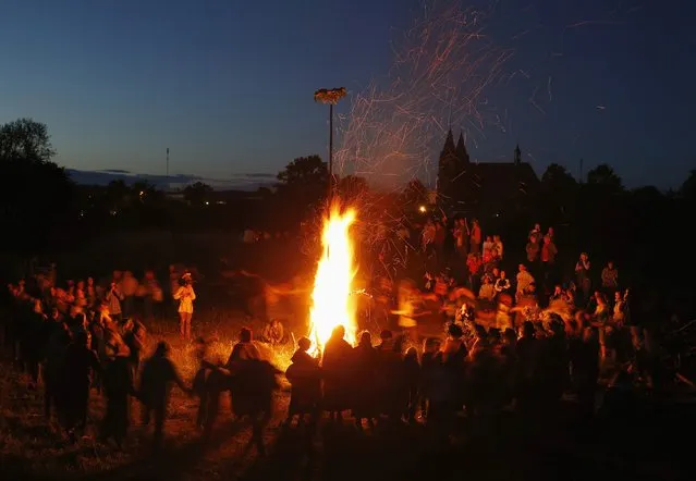 People take part in the Ivan Kupala festival near the town of Rakov, west of Minsk June 27, 2014. The ancient tradition, originating from pagan times, is usually marked with grand overnight festivities. On Kupala Night people sing and dance around campfires, believing it will purge them of their sins and make them healthier. (Photo by Vasily Fedosenko/Reuters)