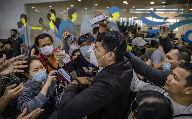 Airport security staff attempt to control the crowd as Filipinos hoping to get on flights out of Manila hours before it is placed on lockdown flock at Ninoy Aquino International Airport on March 14, 2020 in Manila, Philippines. Philippine President Rodrigo Duterte announced on Thursday that he would place some 12 million people in the capital Manila on lockdown and suspend government work for a month to prevent the spread of COVID-19. The Philippines' Department of Health has so far confirmed 98 cases of the deadly coronavirus in the country, with at least 8 recorded fatalities. (Photo by Ezra Acayan/Getty Images)